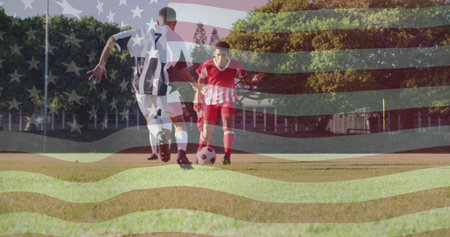 Dribbling male soccer athlete in red kit controlling ball on grassy sports pitch, with flag overlay. Athletes, competition, sportswear, outdoor, team, fitness, recreationの写真素材