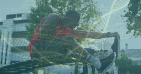 Red-shirted man stretching right leg on parallel bar in park, with earbuds, trainers, DNA overlay. Fitness, wellness, outdoor, sport, health, technology, vitalityの写真素材