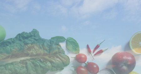 Swiss chard leaf floating over pale blue sky, with basil, tomatoes, chili, onion, lemon and apple. Vegetables, culinary, fresh, organic, vibrant, modern, naturalの写真素材