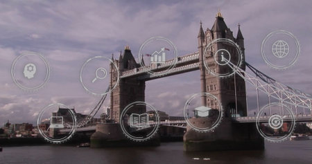 Showcasing Tower Bridge spanning River Thames at London riverside, with digital icons overlaying. Landmark, architecture, skyline, connectivity, education, technology, urbanの写真素材