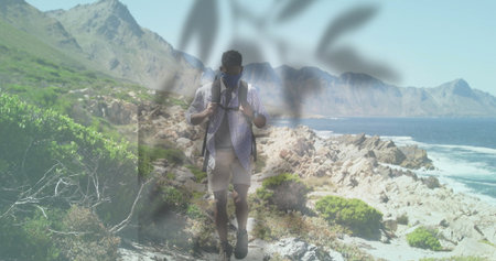 Adjusting backpack straps, male hiker navigating rocky coastal trail, with sunglasses face mask. Adventure, exploration, outdoor, rugged, coastal, nature, wildernessの写真素材