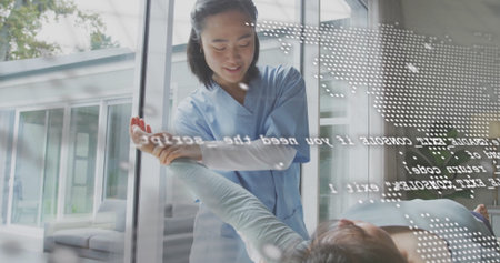 Holding patient forearm therapist in blue scrubs guiding stretch through glass partition in clinic. Rehabilitation, physiotherapy, healthcare, recovery, wellness, technology, modernの写真素材