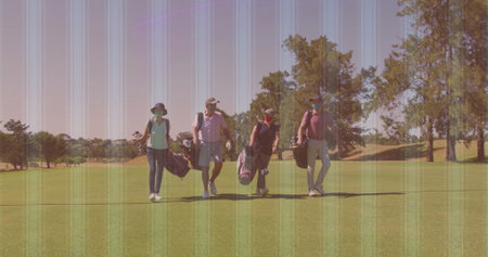 Walking four golfers carrying golf bags down golf course fairway, wearing caps, sunhat and gloves. Outdoor, leisure, sports, team, activity, lifestyle, vibrantの写真素材