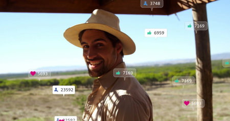 Smiling adult traveler turning head under wooden terrace, with straw hat, social icons, copy space....