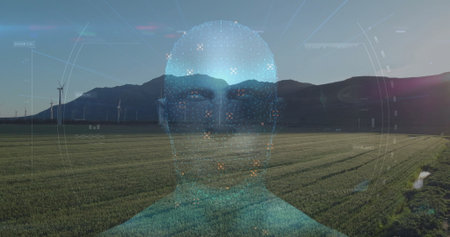 Floating digital holographic head displaying UI elements above crop rows at dawn with wind turbines. Futuristic, renewable, eco-friendly, technology, innovation, sustainable, panoramicの写真素材