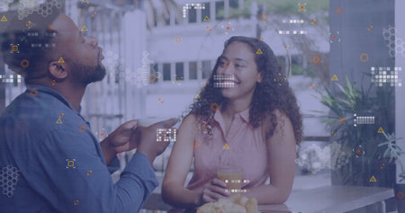 Chatting couple gesturing, sipping orange juice at patio table with croissants and overlay graphics. Romantic, leisure, outdoor, lifestyle, modern, vibrant, relaxationの写真素材