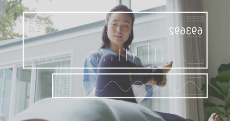 Stretching Korean therapist holding patient leg on table in therapy room with digital overlays. Wellness, therapy, health, rehabilitation, biomechanics, digital, modernの写真素材