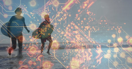 Running couple wearing wetsuits and carrying surfboards in shallow water with neon circuit overlay. Technology, adventure, motion, futuristic, coastal, active, connectivityの写真素材