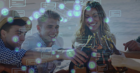 Five friends in summer clothes clinking beer bottles on beach by sea, with digital chat icons. Casual, celebration, relaxation, communication, outdoor, leisure, vibrantの写真素材