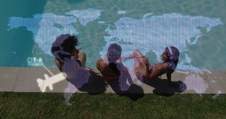Sitting women in swimsuits dangling legs over coping at backyard pool, with digital map overlay. Leisure, relaxation, friendship, summer, outdoor, modern, technologyの写真素材