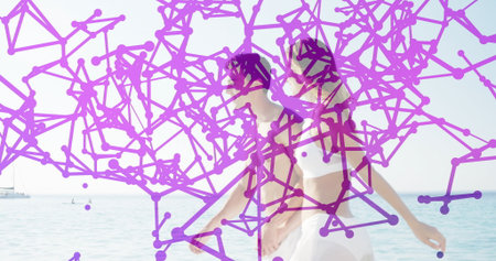 Bikini-clad mid adult woman and man kissing in shallow turquoise sea at beach, with selfie pole. Romance, travel, vacation, tropical, serenity, leisure, affectionの写真素材