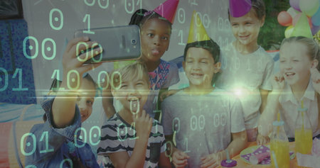 Taking selfie six children wearing cone-shaped party hats in backyard, with smartphone and balloons. Celebration, childhood, friendship, outdoor, festivity, joyful, playfulの写真素材