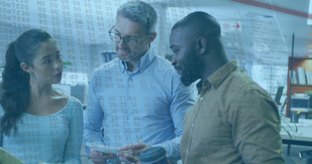 Team of three collaborating in office, reviewing tablet, checking smartphone and holding coffee mug. Collaboration, teamwork, innovation, modernity, productivity, digital, professionalの写真素材