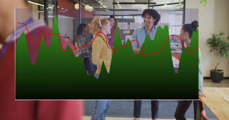 Collaborating coworkers wearing business attire standing around table in office with chart overlay....