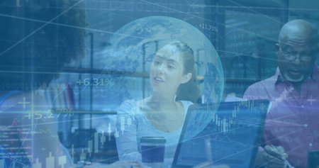 Reviewing stock charts, Korean woman leading discussion in office, with laptops and digital charts....