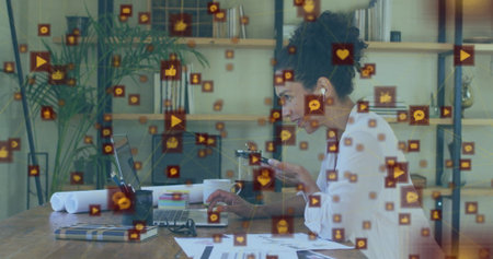 Typing woman in blouse checking smartphone amid social media icons in home office, with laptop....
