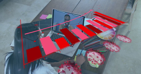 Taking notes woman in blouse holding pen at office table, with laptop displaying chart, virus data....