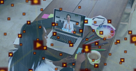 African American woman taking notes during virtual call in home office, with laptop, color wheel....