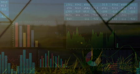 Displaying data overlays showing charts and tables on grassy field at sunset, with fence wires. Futuristic, outdoor, natural, vibrant, analysis, technology, landscapeの写真素材