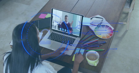 Woman in blouse joining conference on laptop in studio, with color wheel, coffee mug, copy space....