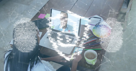 Designer joining meeting on laptop at home desk, with notes swatch fingerprint graphics, copy space. Workspace, collaboration, digital, creativity, innovation, professional, communicationの写真素材