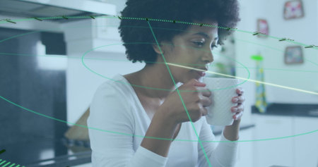 Sipping morning drink curly-haired woman holding mug in bright white kitchen, with fridge magnets. Modern, cozy, vibrant, lifestyle, culinary, minimalist, warmの写真素材