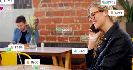 Calling worker wearing glasses and jacket on smartphone at cafe, with social alerts, copy space....