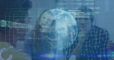 Collaborating developers typing code at office desk, with monitors, keyboard and holographic globe. Technology, innovation, teamwork, contemporary, digital, data-driven, professionalの写真素材