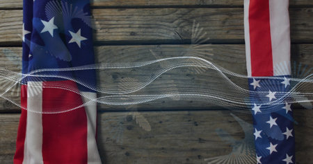 Displaying pair of U.S. flag fabric strips on wooden table with dotted wave overlay, copy space....