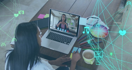 Woman writing notes during virtual call in home office, with laptop, sticky notes, pen, copy space....