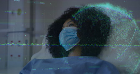 Reclining patient on hospital bed wearing surgical mask and medical gown, displaying data graphics. Health, telemedicine, digital, futuristic, clinical, wellness, healthcareの写真素材