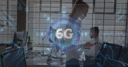 Gesturing businesswoman presenting 6G interface in modern office, with multiple monitors....
