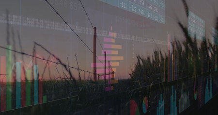 Displaying barbed wire fence and grain stalks framing silo at twilight, overlaying finance charts. Rural, landscape, agriculture, sunset, digital, data, technologyの写真素材