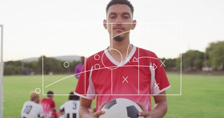 Soccer player holding black-and-white ball on field, with tactical overlay and metal goal post....
