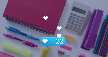 Floating blue like bubble showing 23 likes over flat-lay workspace, with red notebook and pens....