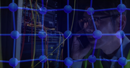 Holding smartphone technician managing digital network nodes in server room with cables, copy space....