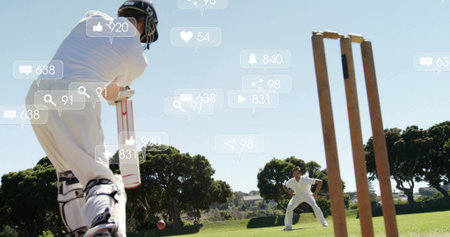 Holding bat preparing to hit ball in white uniform at cricket ground, social icons, copy space. Athletics, competition, outdoor, recreation, athleticism, sportsmanship, fitnessの写真素材