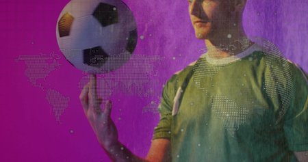 Showcasing soccer player in green jersey balancing soccer ball on tip in studio, dotted world map. Athlete, sport, motion, digital, dynamic, vibrant, fitnessの写真素材