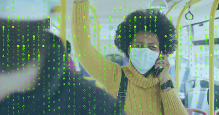 Masked commuter in yellow sweater gripping strap and calling on smartphone on bus, with data stream....