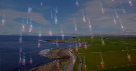 Displaying winding paved coastal road hugging shoreline above farmland, with binary code overlay....