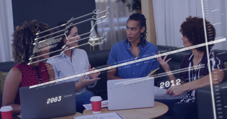 Collaborating coworkers around table in office lounge, with laptops, coffee cups, timeline graphics....