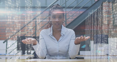 Holding palms open woman wearing grey shirt at wooden desk in office, with floating code streams. Technology, innovation, workspace, professional, digital, modern, collaborationの写真素材