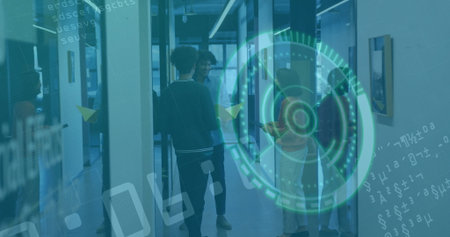 Three colleagues discussing smartphone interface graphics in office corridor, with glass partitions....