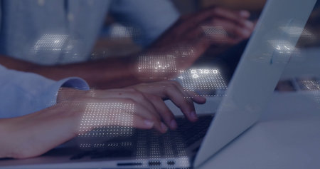 Typing professional hands entering data on laptops in modern office, with glowing digital overlay. Technology, collaboration, innovation, digital, modernity, productivity, workspaceの写真素材