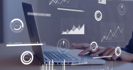Typing office worker wearing dark top analyzing data on laptop at office desk, with graph overlays....
