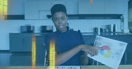 Pointing businesswoman wearing blouse indicating pie chart at office kitchenette, with bar graph....