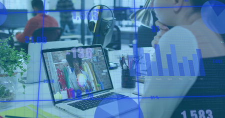 Watching office worker joining remote clothing presentation at office desk with laptop, copy space. Collaboration, digital, productivity, connection, modernity, communication, professionalの写真素材