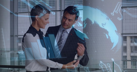 Colleagues in business attire examining smartphone data overlay near glass railing in office....