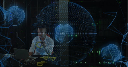 Engineer wearing tie plugging yellow Ethernet cables at server room desk, with network globes. Technology, cybersecurity, data, connectivity, innovation, digital, infrastructureの写真素材
