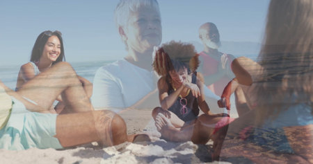 Meditating senior woman wearing T shirt holding prayer pose on sandy beach, with sunglasses....